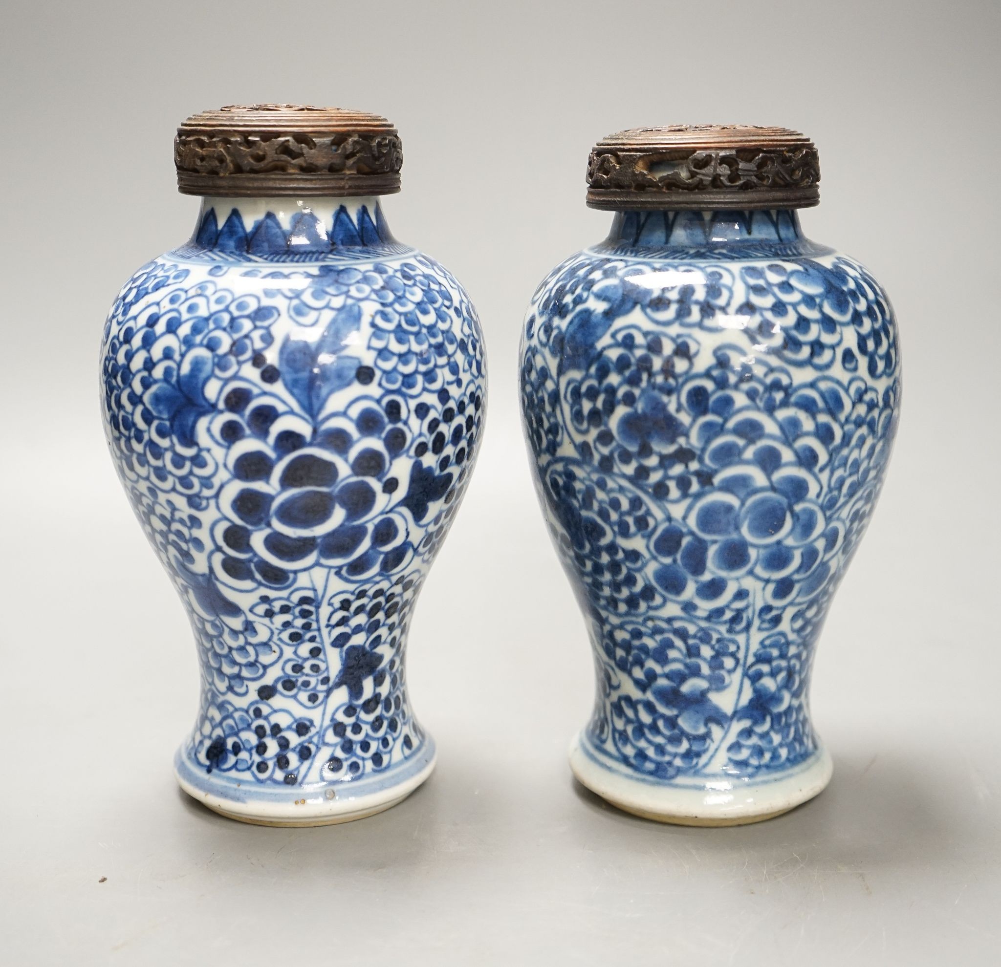 A pair of Chinese blue and white 'phoenix' vases, Kangxi, associated wood covers, 19cm including covers